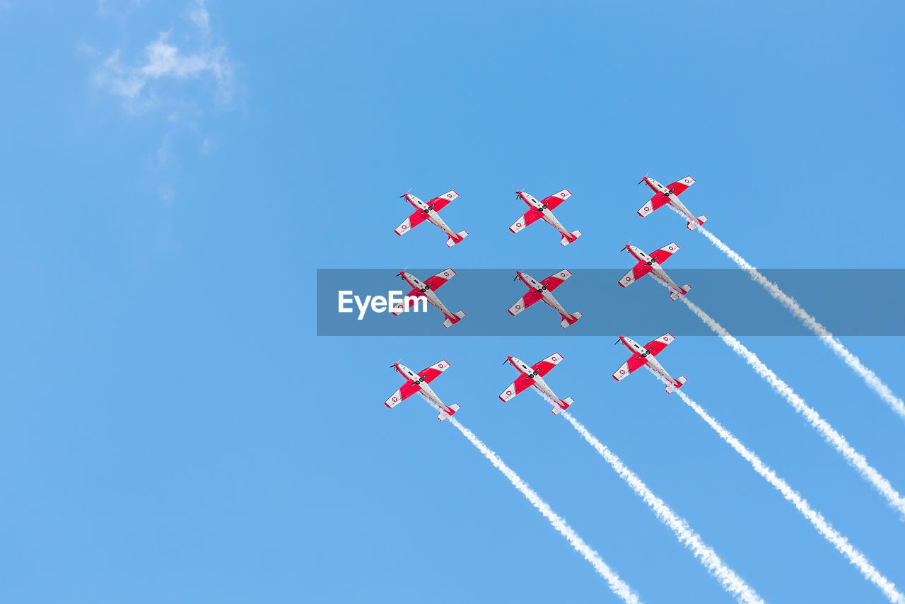 LOW ANGLE VIEW OF RED AIRSHOW AGAINST SKY