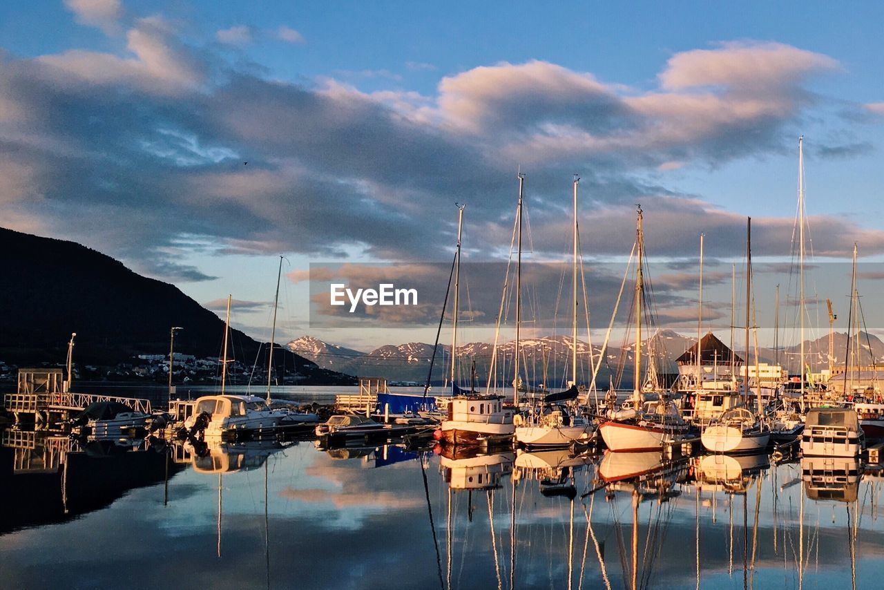 BOATS MOORED AT SEA AGAINST SKY