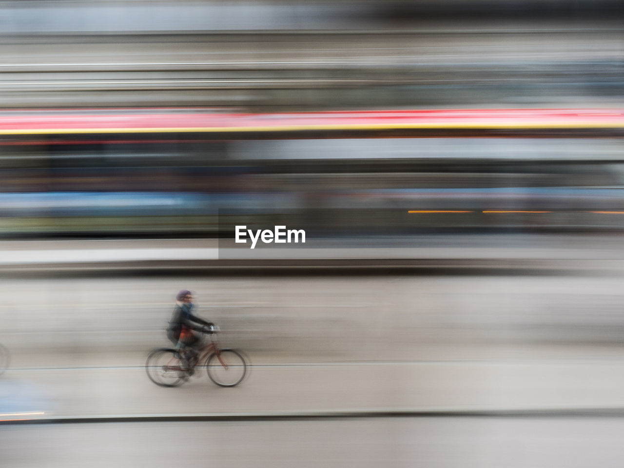 Blurred motion of man cycling on bicycle in city