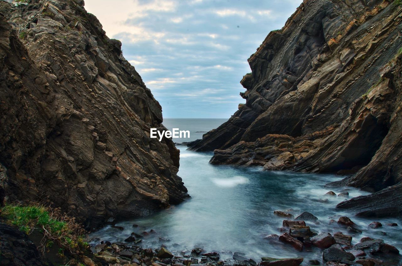 Scenic view of sea and mountains against sky