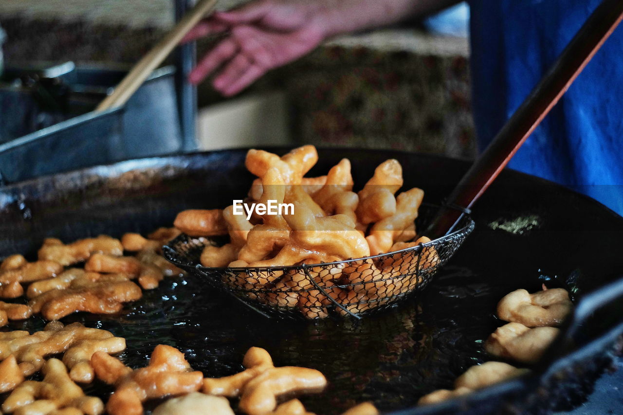 CROPPED IMAGE OF PERSON PREPARING FOOD ON BARBECUE