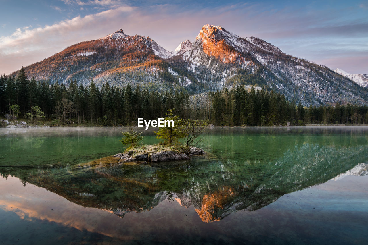 Scenic view of lake by mountains against sky