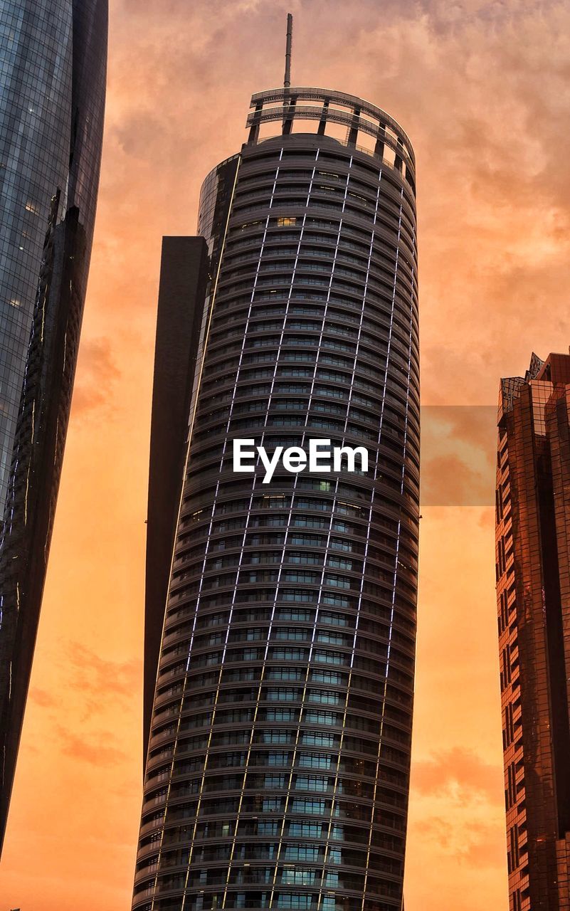 LOW ANGLE VIEW OF MODERN BUILDING AGAINST SKY DURING SUNSET