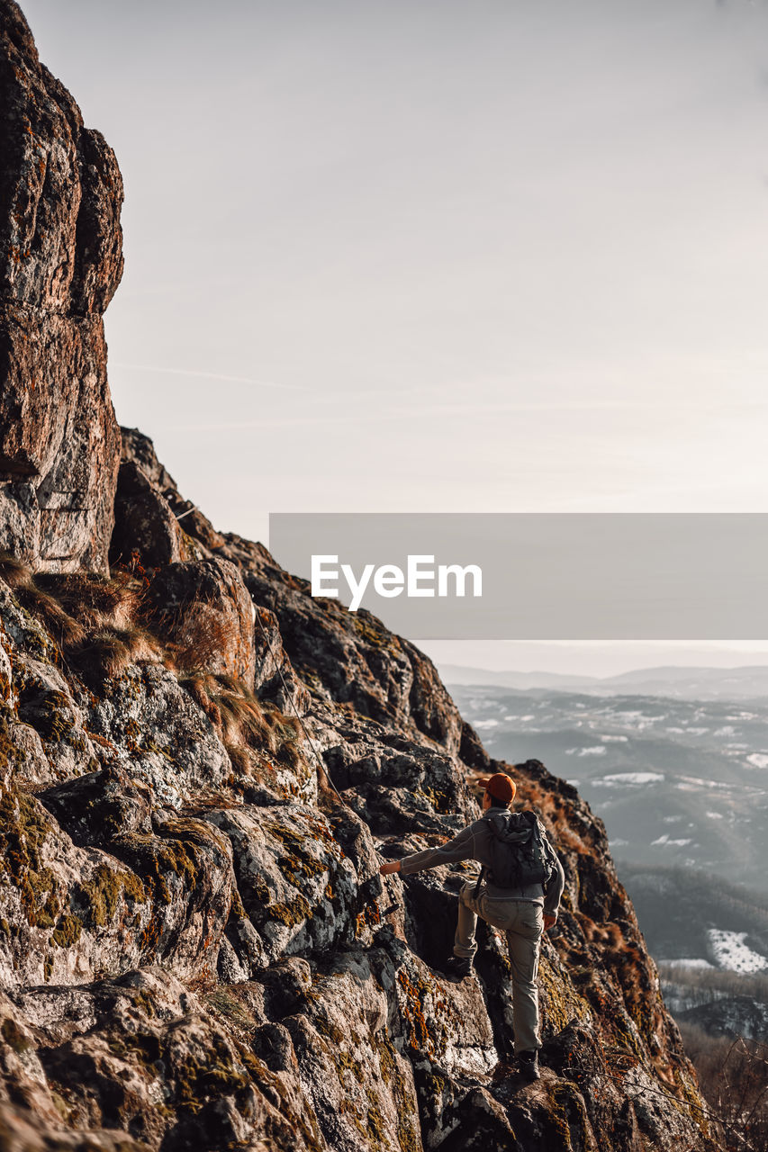 ROCK FORMATION ON CLIFF AGAINST SKY