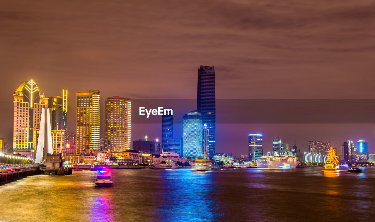 ILLUMINATED MODERN BUILDINGS IN CITY AT NIGHT