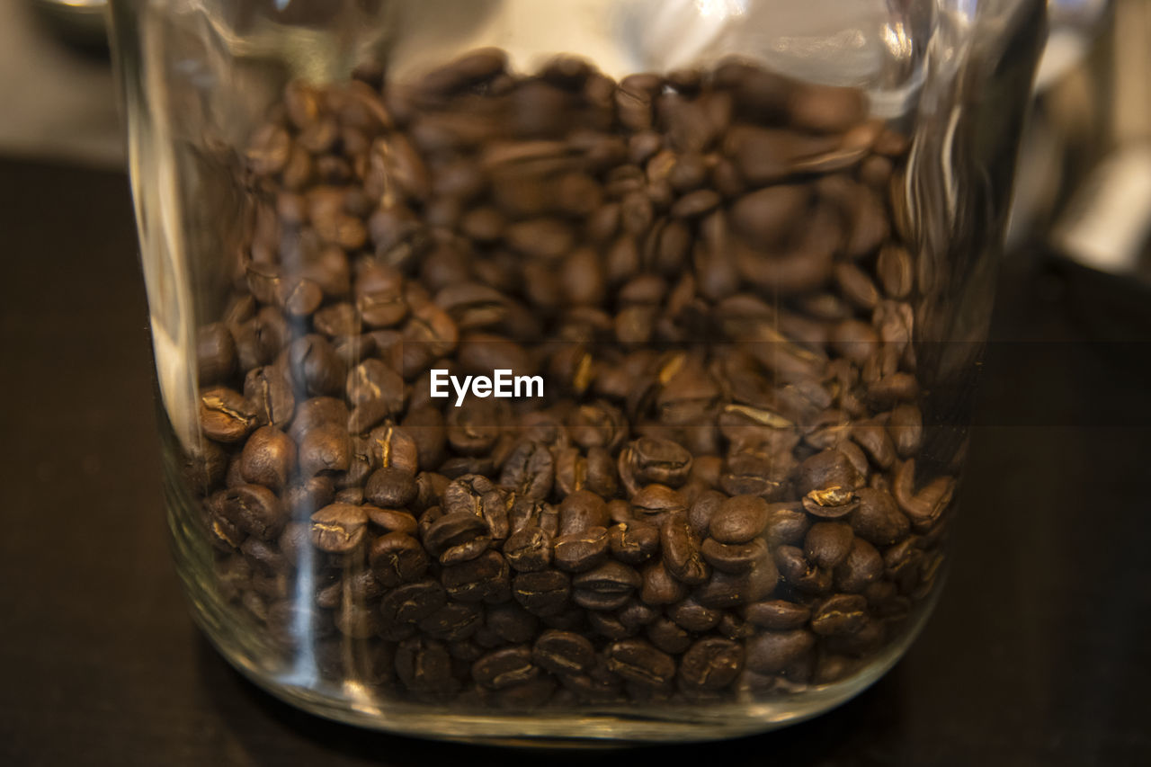 Close-up of coffee beans in glass jar on table