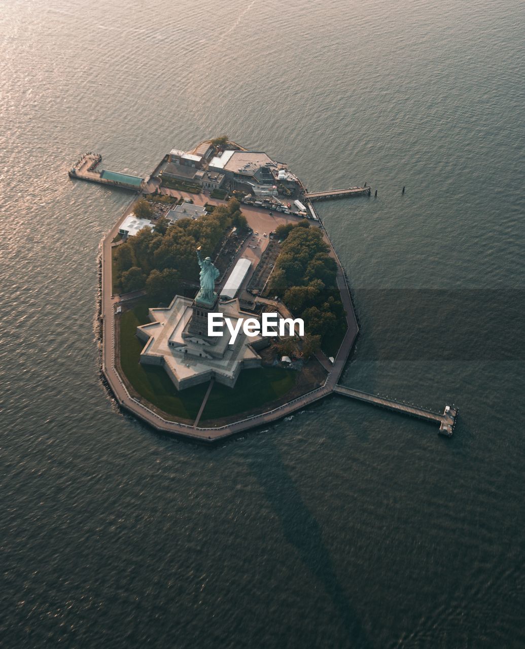 Statue of liberty on island amidst sea in city