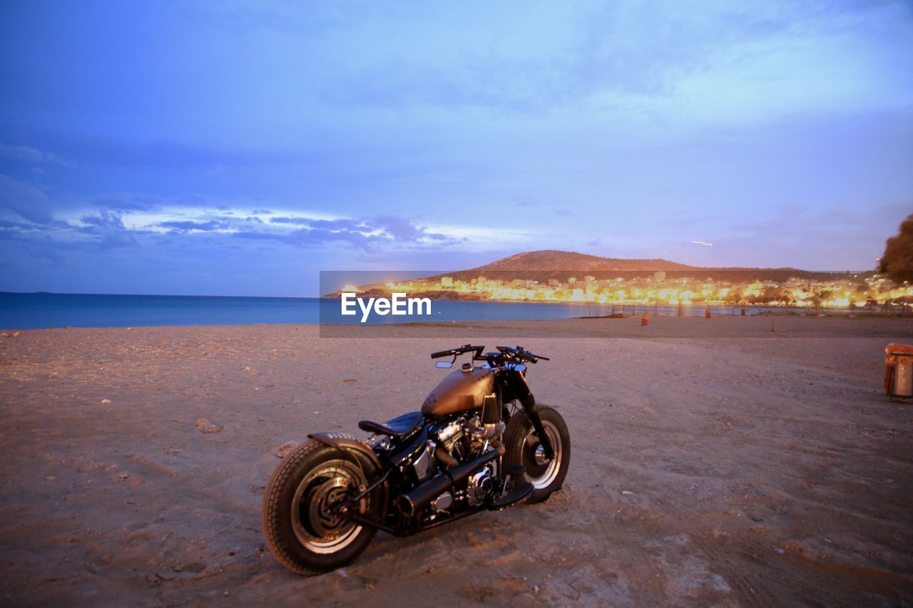 BICYCLES ON BEACH AGAINST SKY