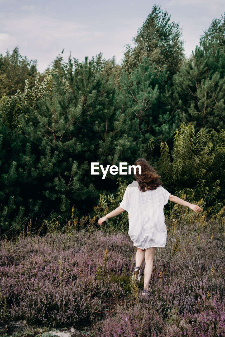 Rear view of woman walking on field