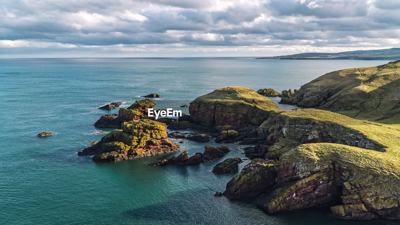 Rock formation in sea against sky