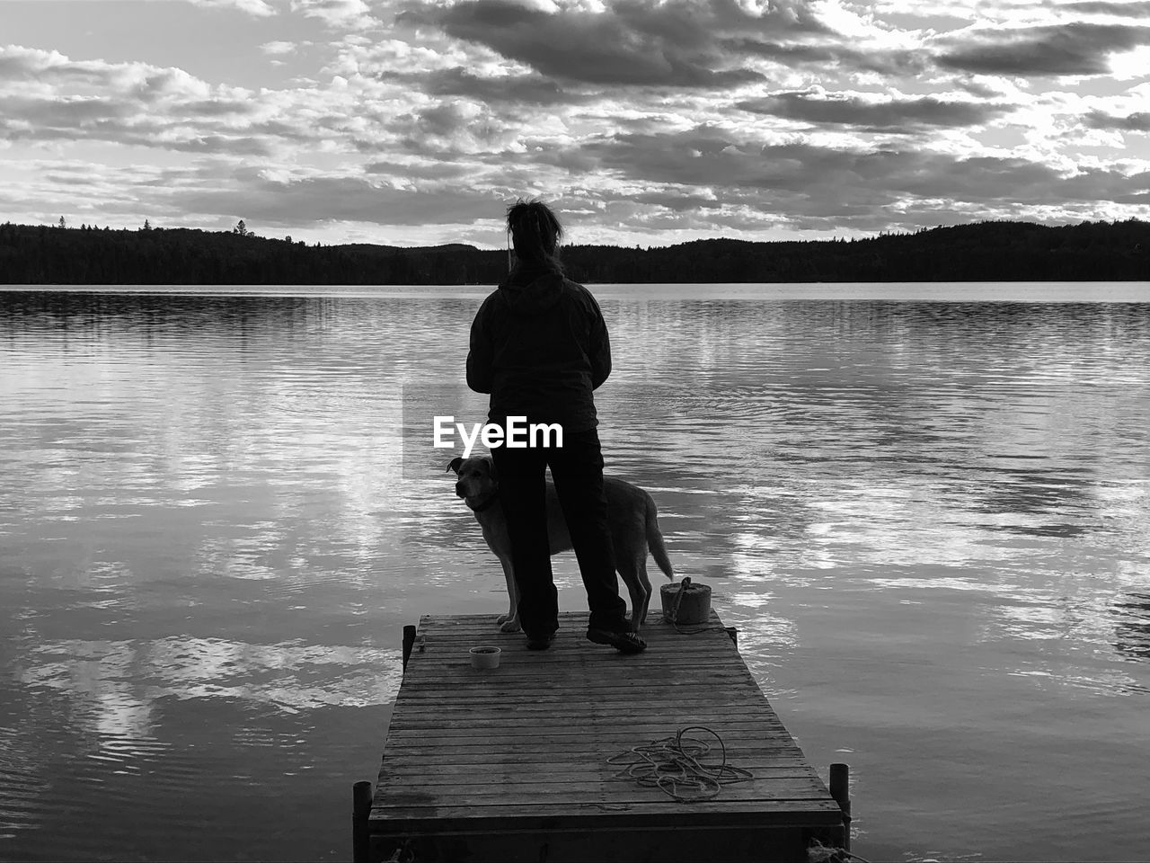 REAR VIEW OF WOMAN ON PIER AGAINST LAKE