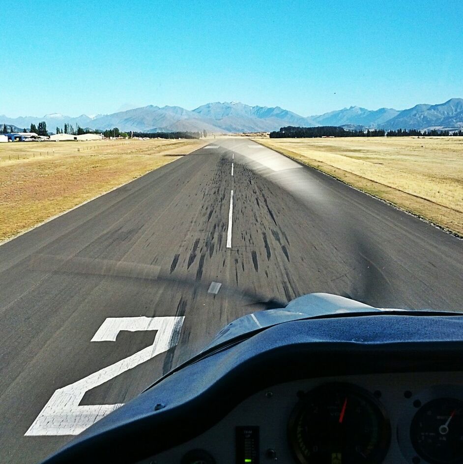 Cropped vehicle speeding on country road along landscape