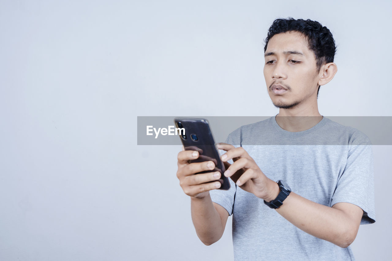 YOUNG MAN USING SMART PHONE