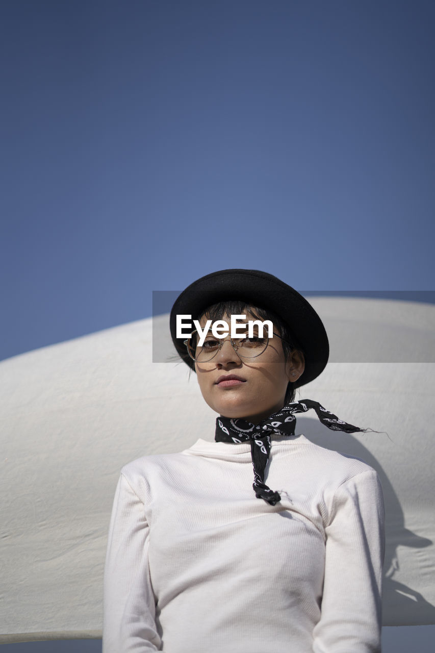 Portrait of man wearing hat against sky in winter