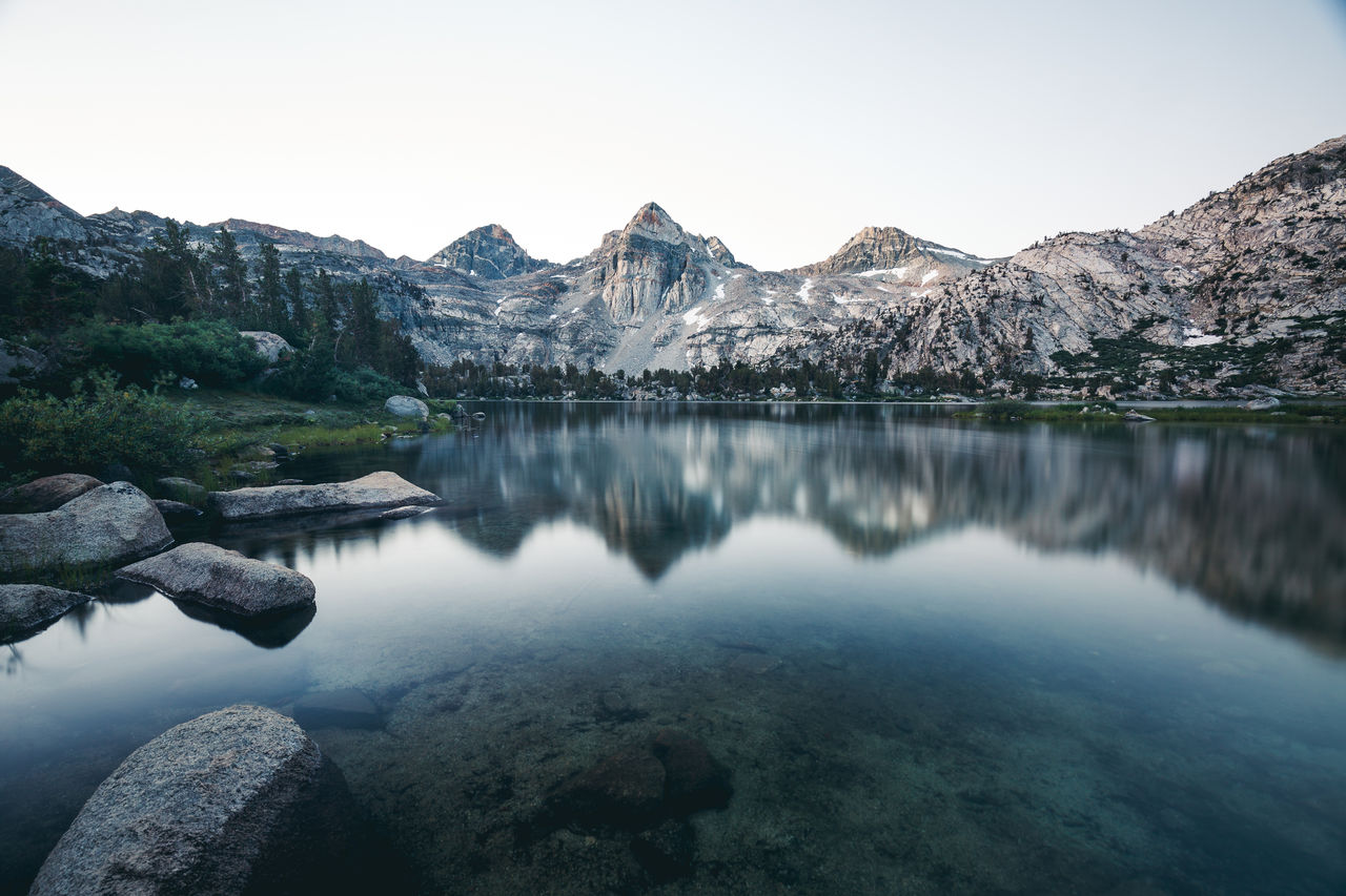 Scenic view of lake and mountains against clear sky