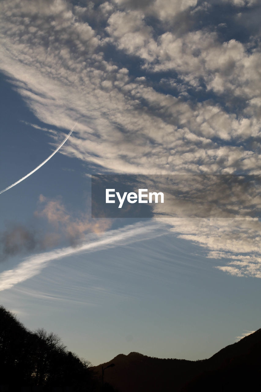 LOW ANGLE VIEW OF VAPOR TRAILS AGAINST SKY