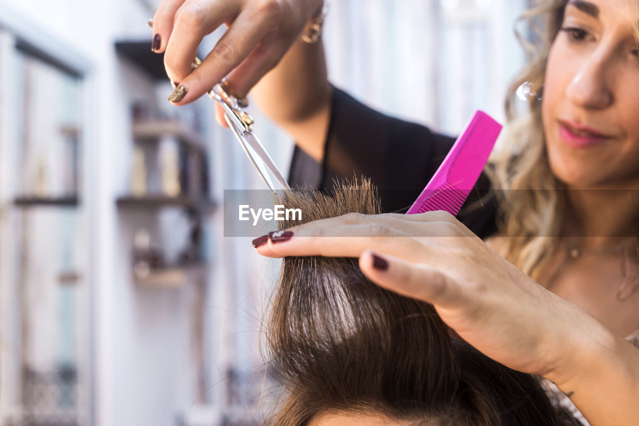 Close-up of a hairdresser cutting the hair of a woman in a beauty salon