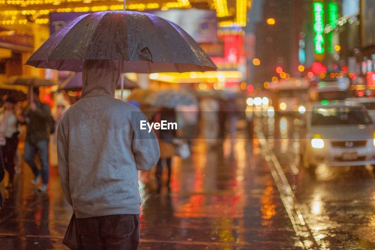 People on times square sidewalk in the rain