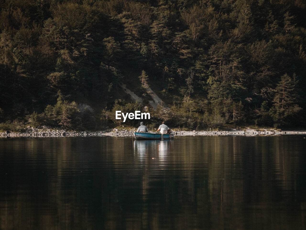 PEOPLE ON BOAT IN LAKE AT FOREST