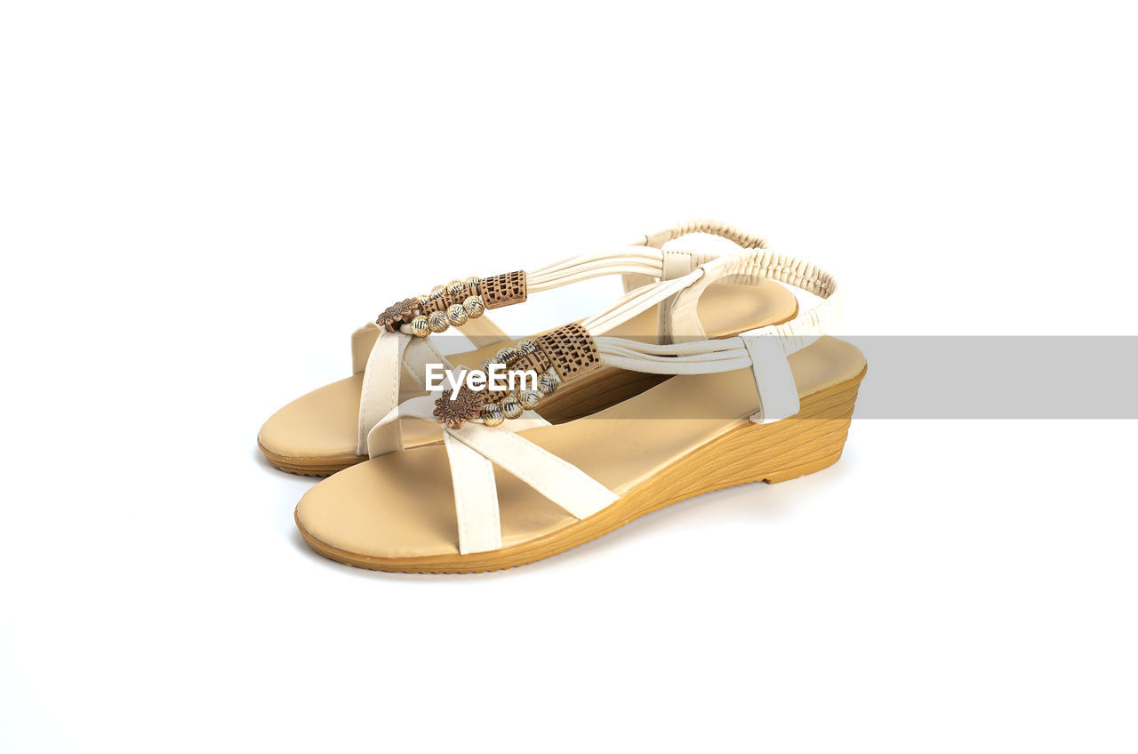 footwear, shoe, cut out, white background, jewelry, fashion, gold, sandal, studio shot, outdoor shoe, human leg, yellow, pair, celebration, copy space, personal accessory, event, tan, indoors, white, ring, leather, wealth, beige, luxury, bridal shoe, limb
