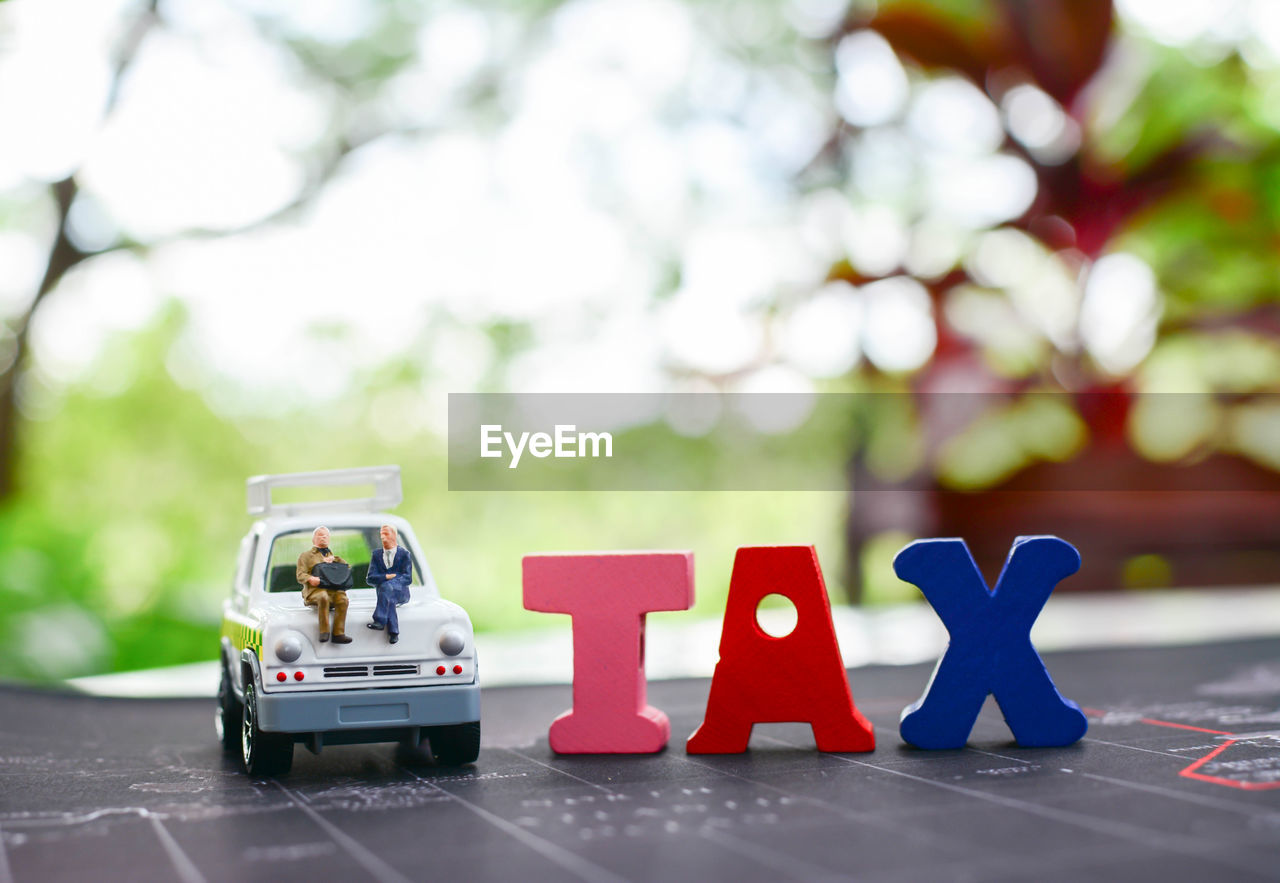 Close-up of text blocks with toy car on table