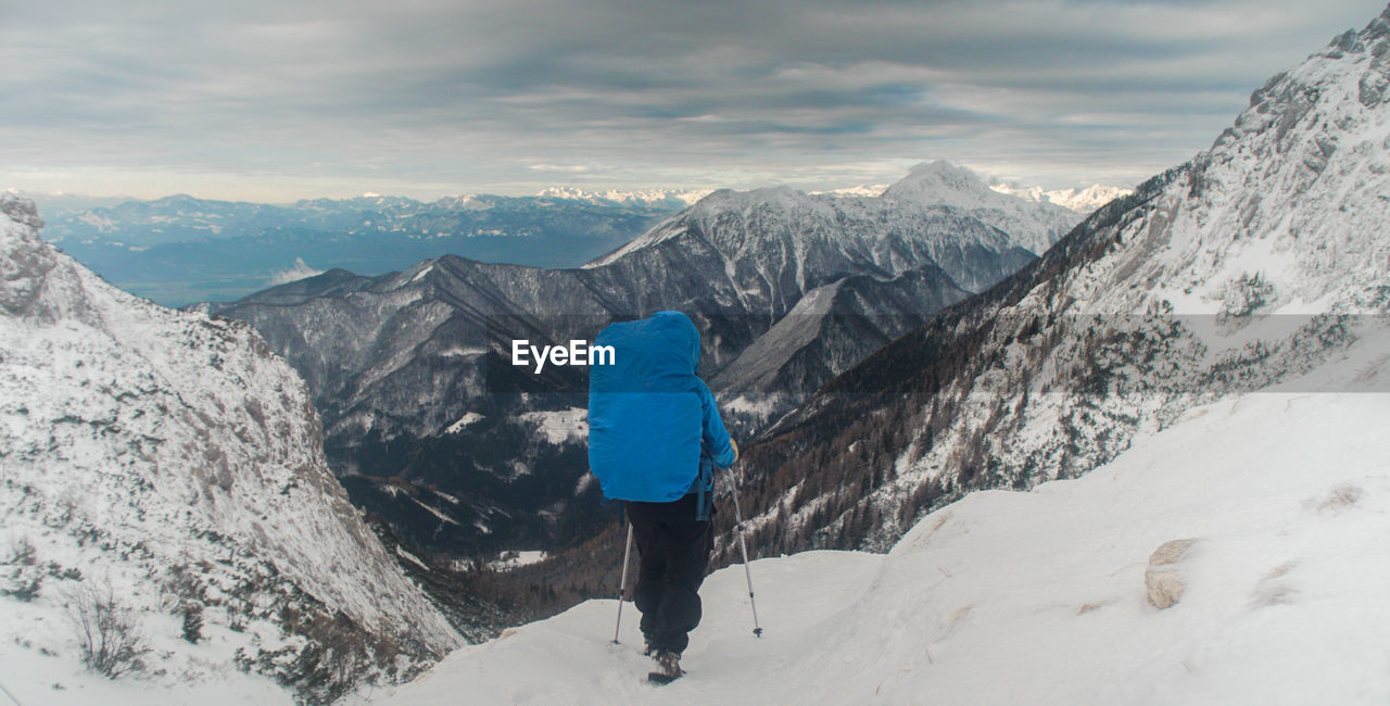 Rear view of person on snowcapped mountains against sky