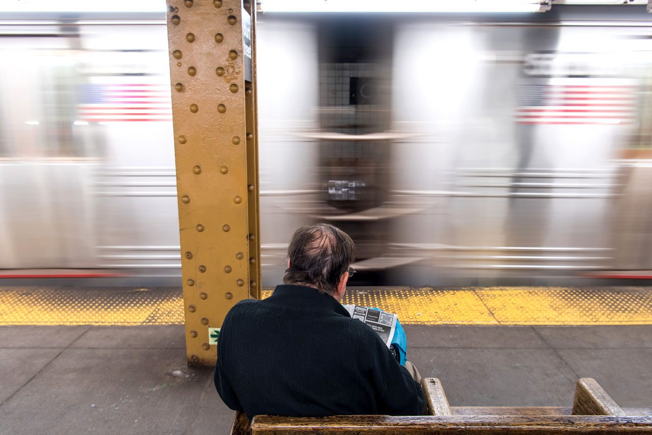 BLURRED MOTION OF TRAIN AT RAILROAD STATION PLATFORM