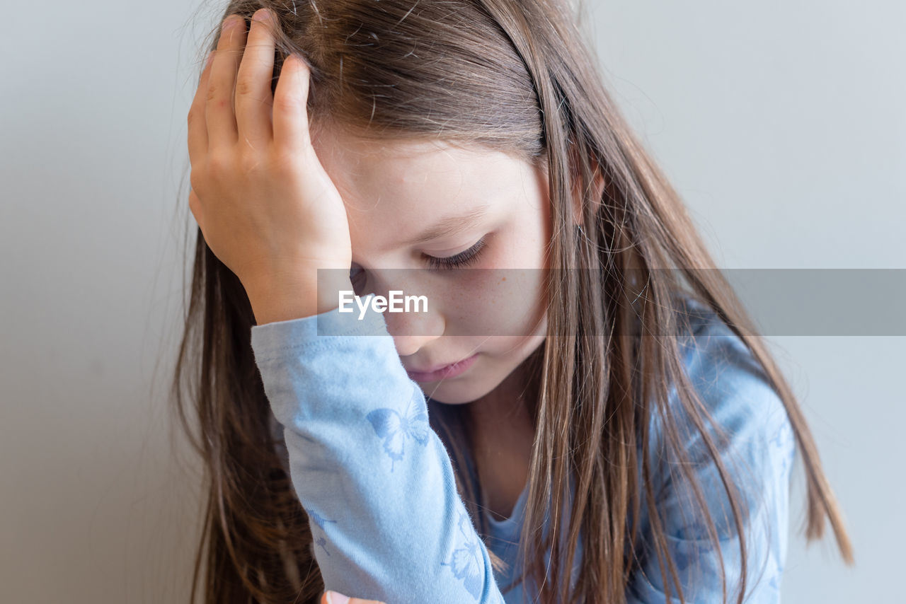 Close-up of thoughtful girl sitting at home