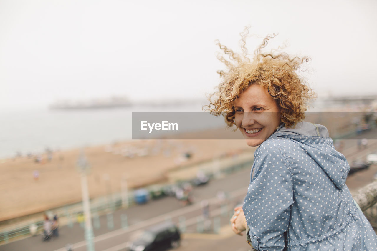 Happy woman at brighton pier against clear sky