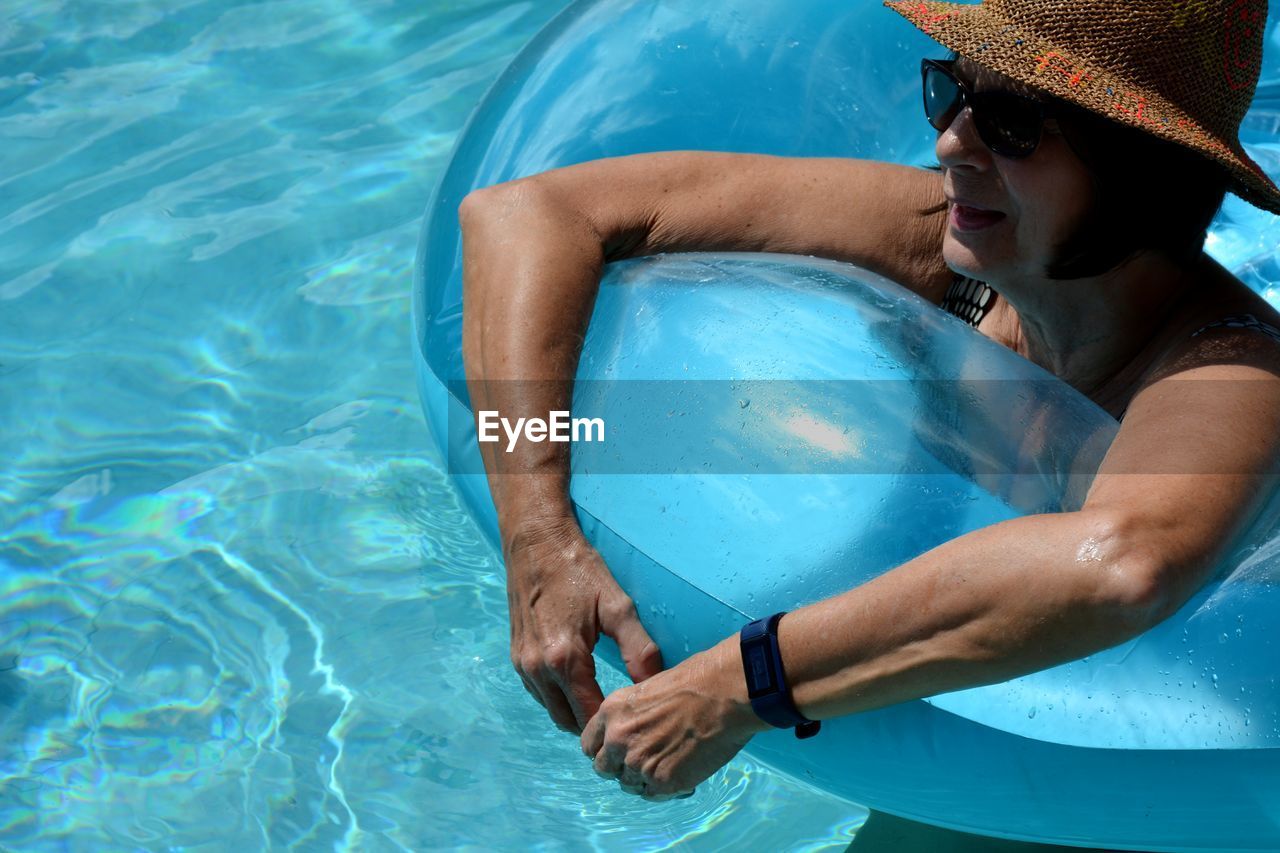 High angle view of woman on inflatable in swimming pool