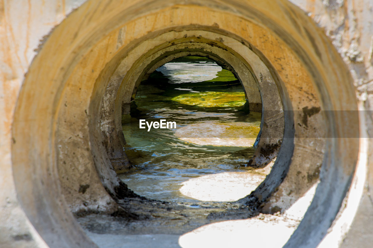 CLOSE-UP OF WATER PIPE SEEN THROUGH OPEN