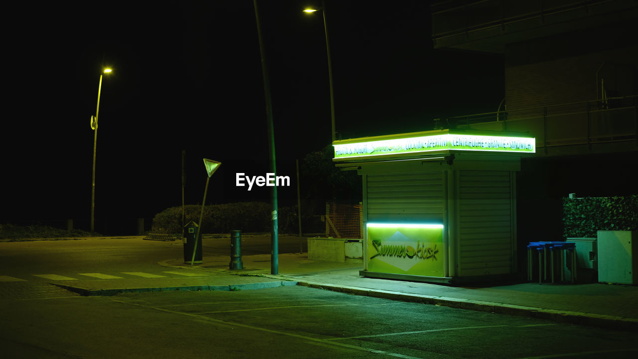 ILLUMINATED SIGN IN FRONT OF BUILT STRUCTURE