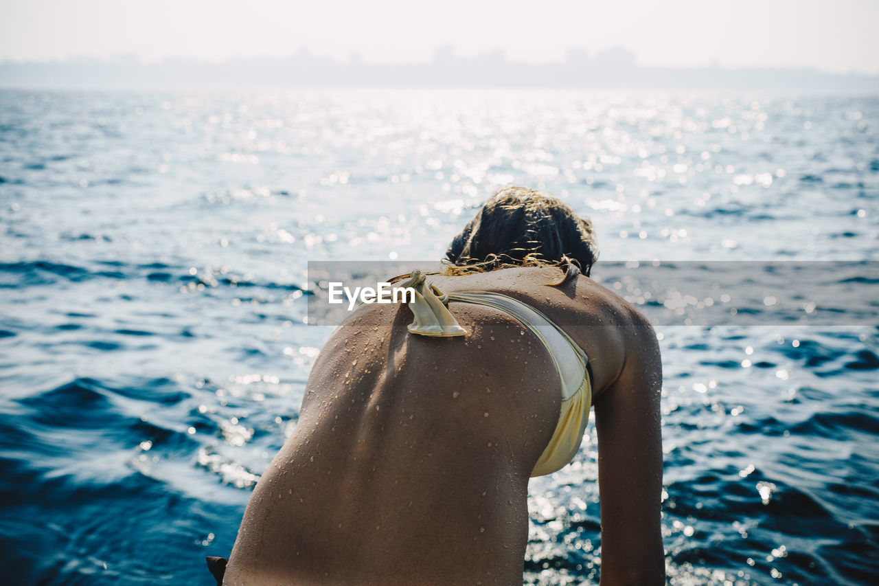 Rear view of young woman looking at sea shore