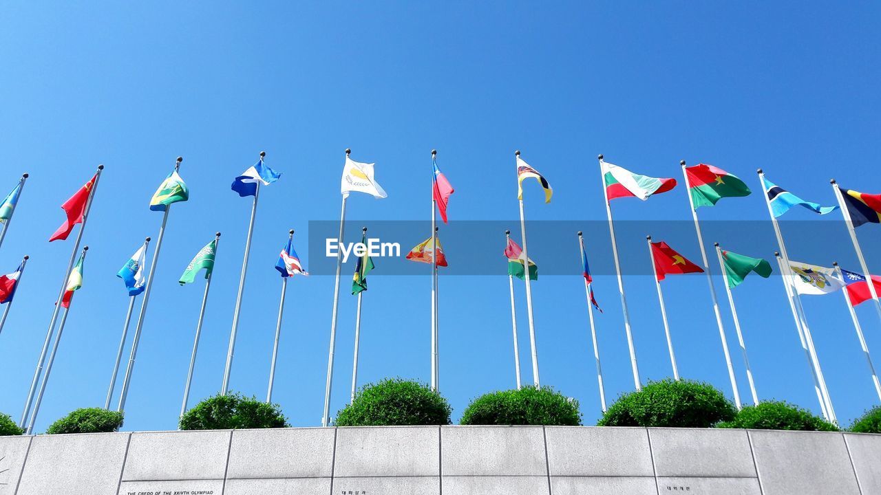 LOW ANGLE VIEW OF FLAGS AGAINST CLEAR SKY