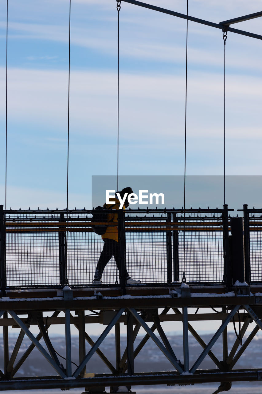 Full length of woman walking on bridge during winter