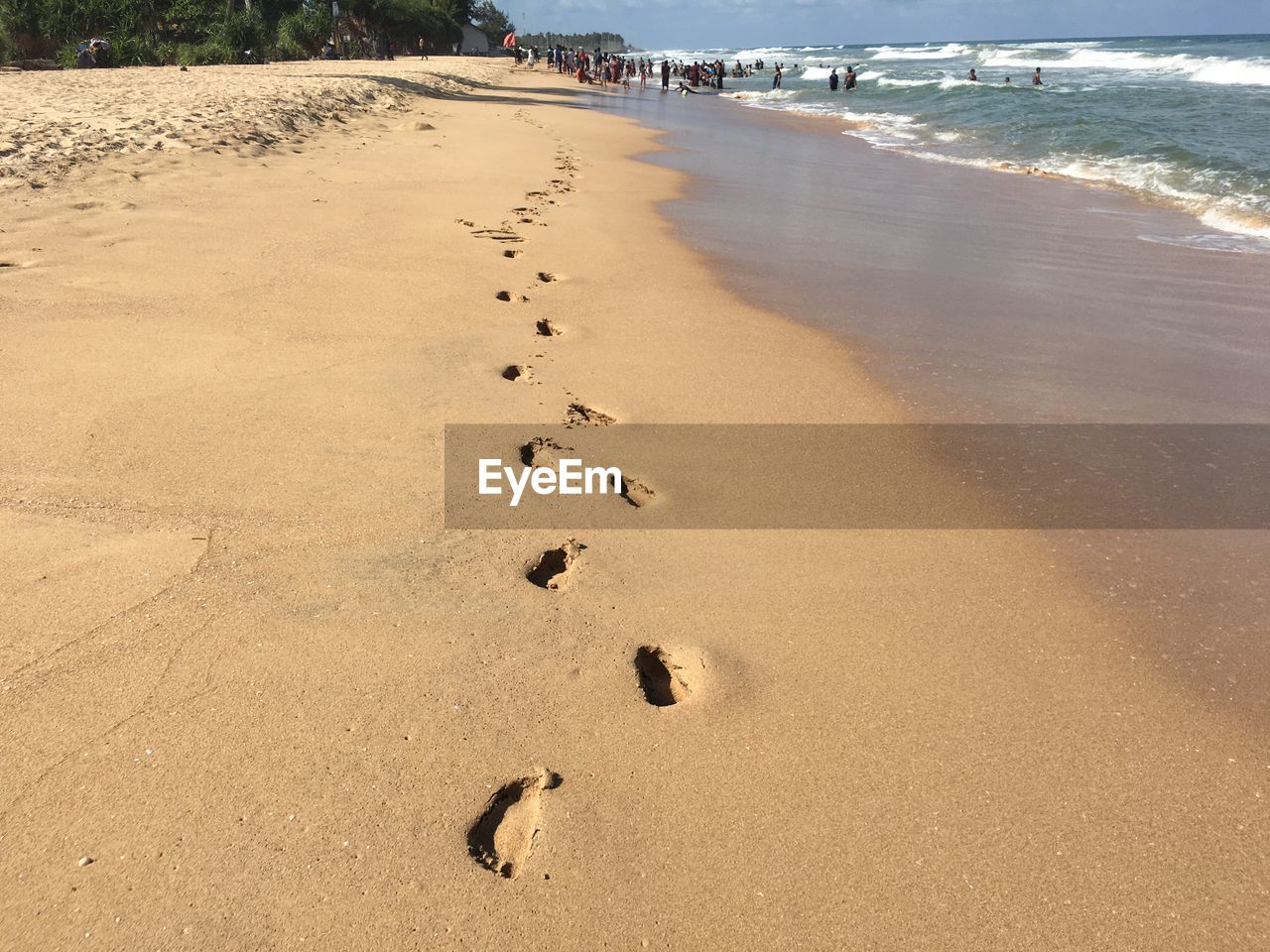 HIGH ANGLE VIEW OF FOOTPRINTS ON WET SAND