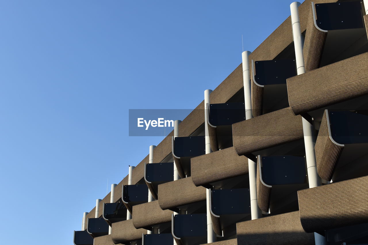 Low angle view of stack against blue sky