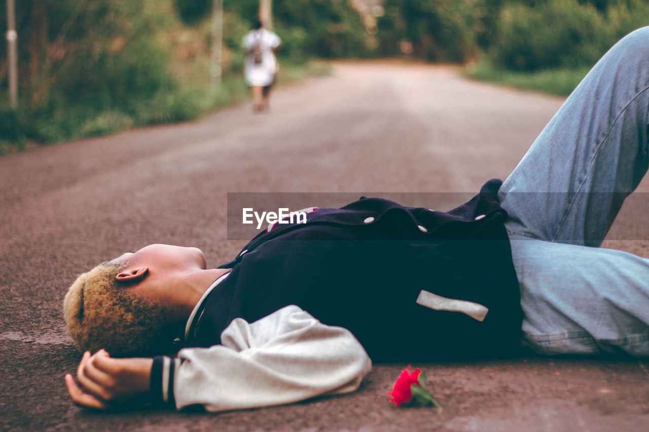 Side view of woman lying on road