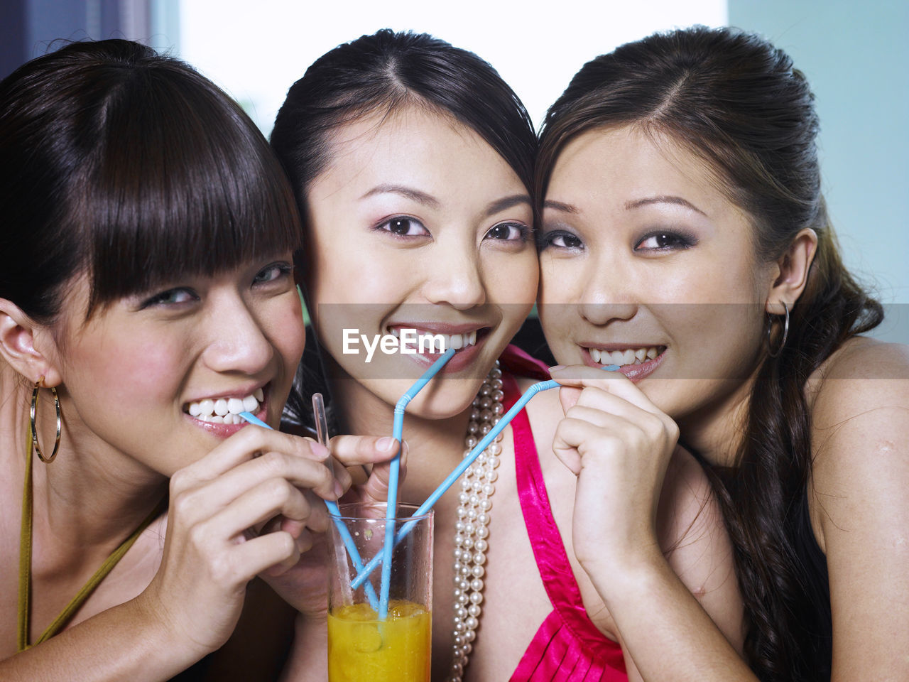 Close-up portrait female friends having drink while sitting in restaurant