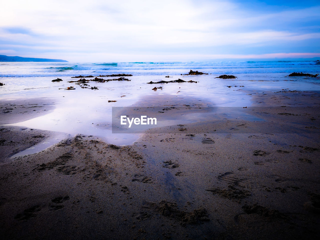 Scenic view of beach against sky with purple hues 