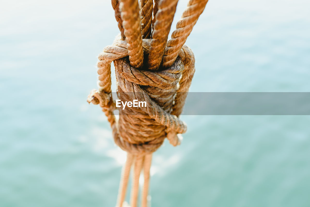 CLOSE-UP OF ROPES TIED ON WOODEN POST