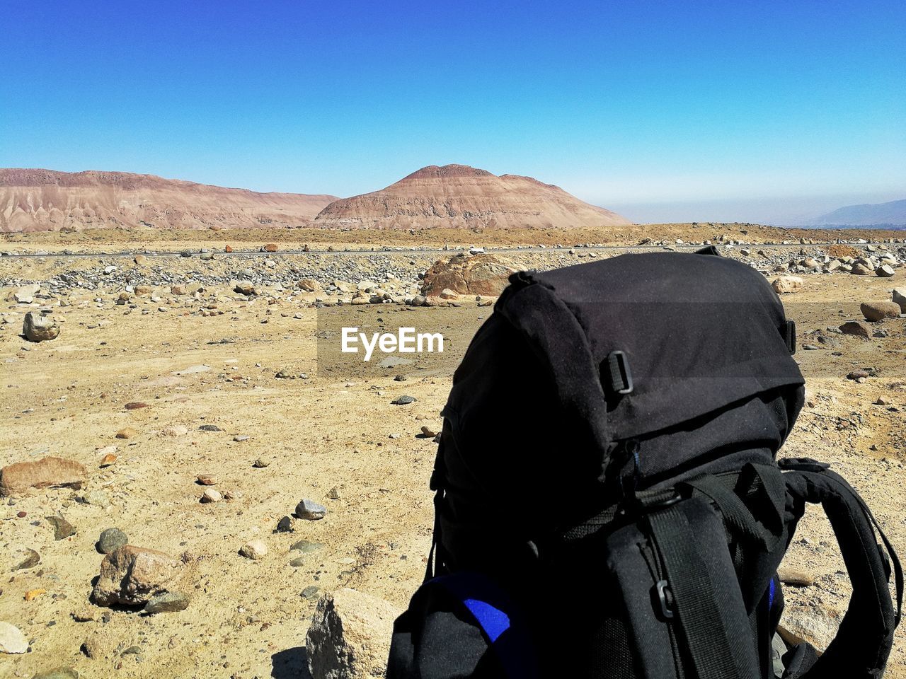 Close-up of backpack on field against sky