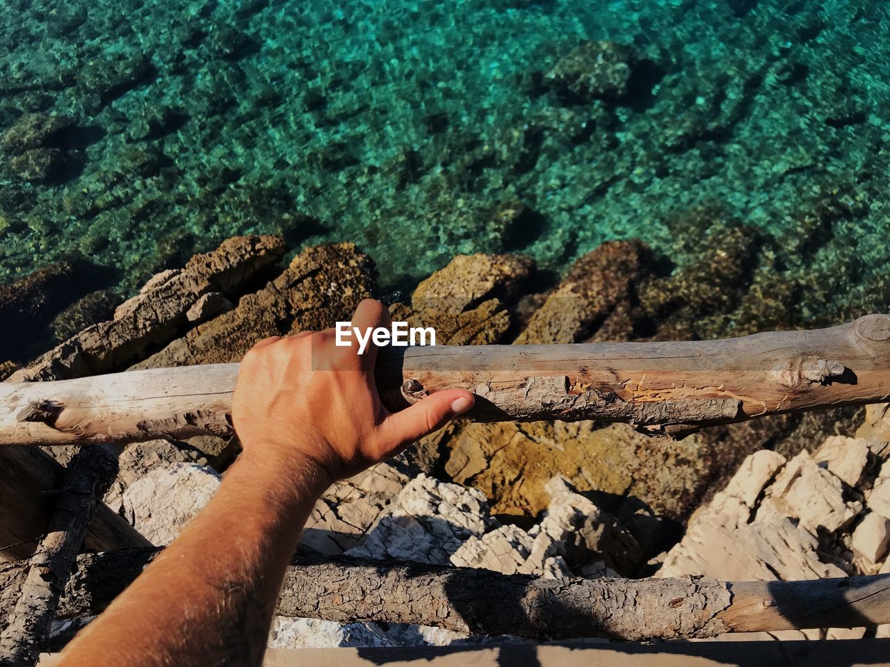 Cropped hand holding wooden railing