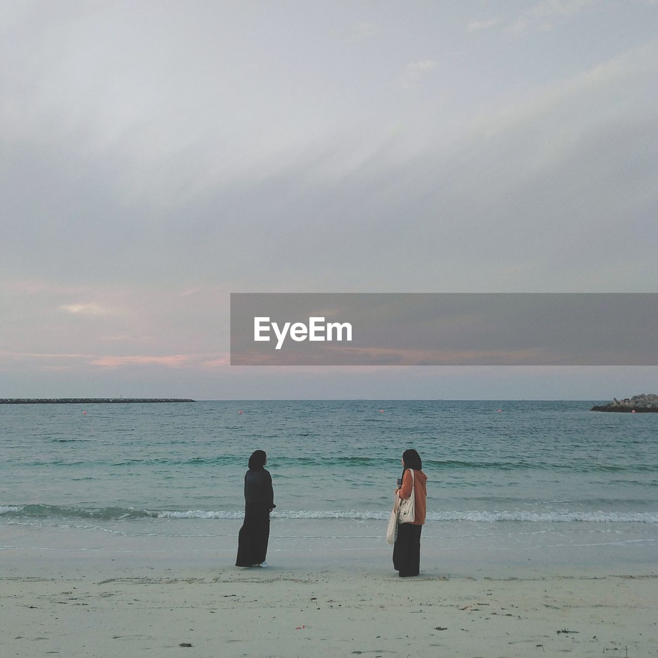 WOMAN ON BEACH AGAINST SKY