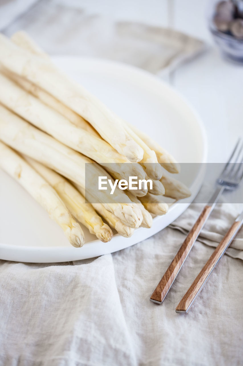 High angle view of white asparagus in plate on table