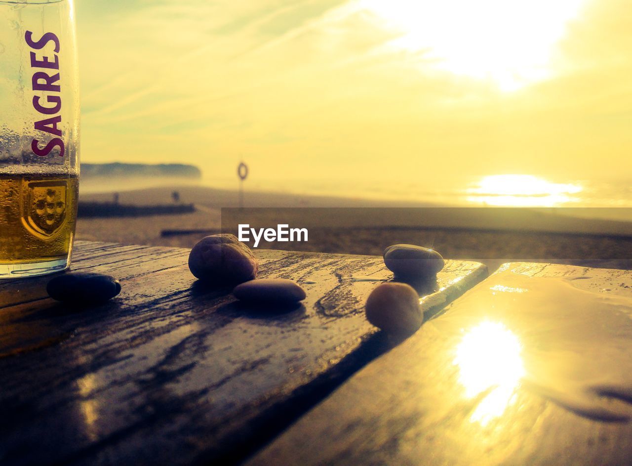 CLOSE-UP OF TEXT ON TABLE AGAINST SKY DURING SUNSET