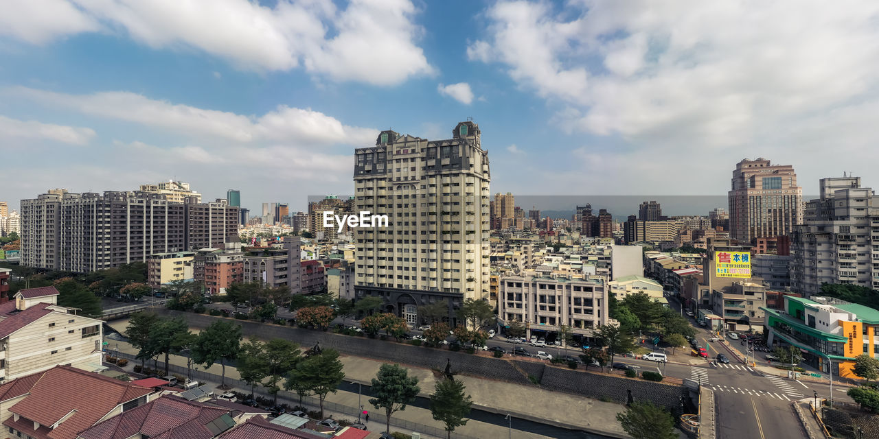 HIGH ANGLE VIEW OF BUILDINGS AND STREET AGAINST SKY