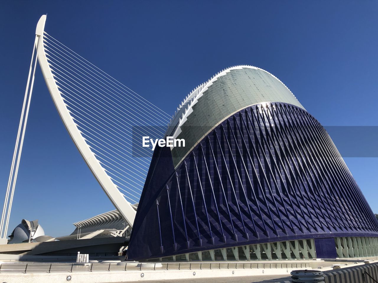 LOW ANGLE VIEW OF MODERN BUILDING AGAINST CLEAR BLUE SKY