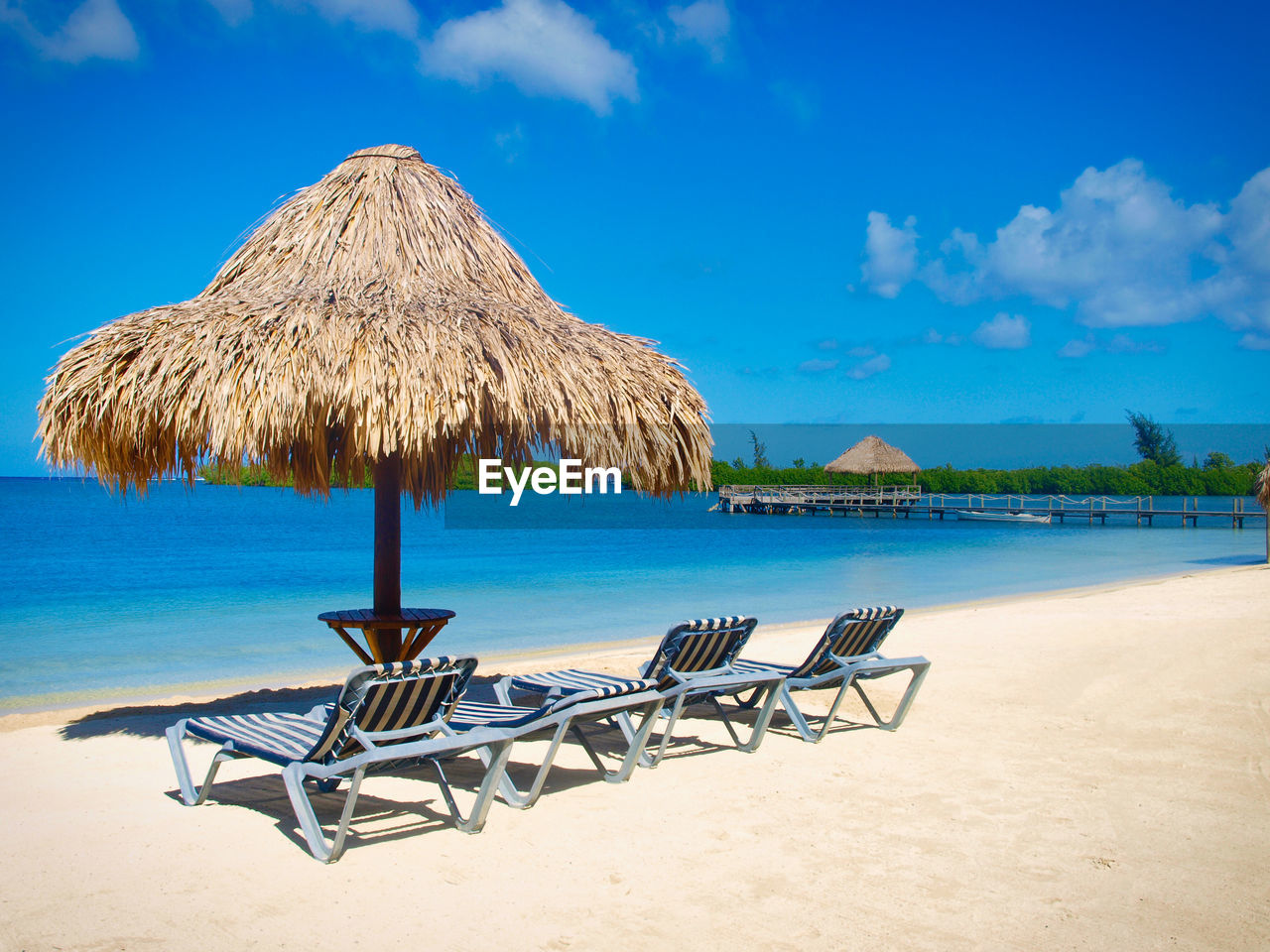 Palapa and beach bed agaist blue sky