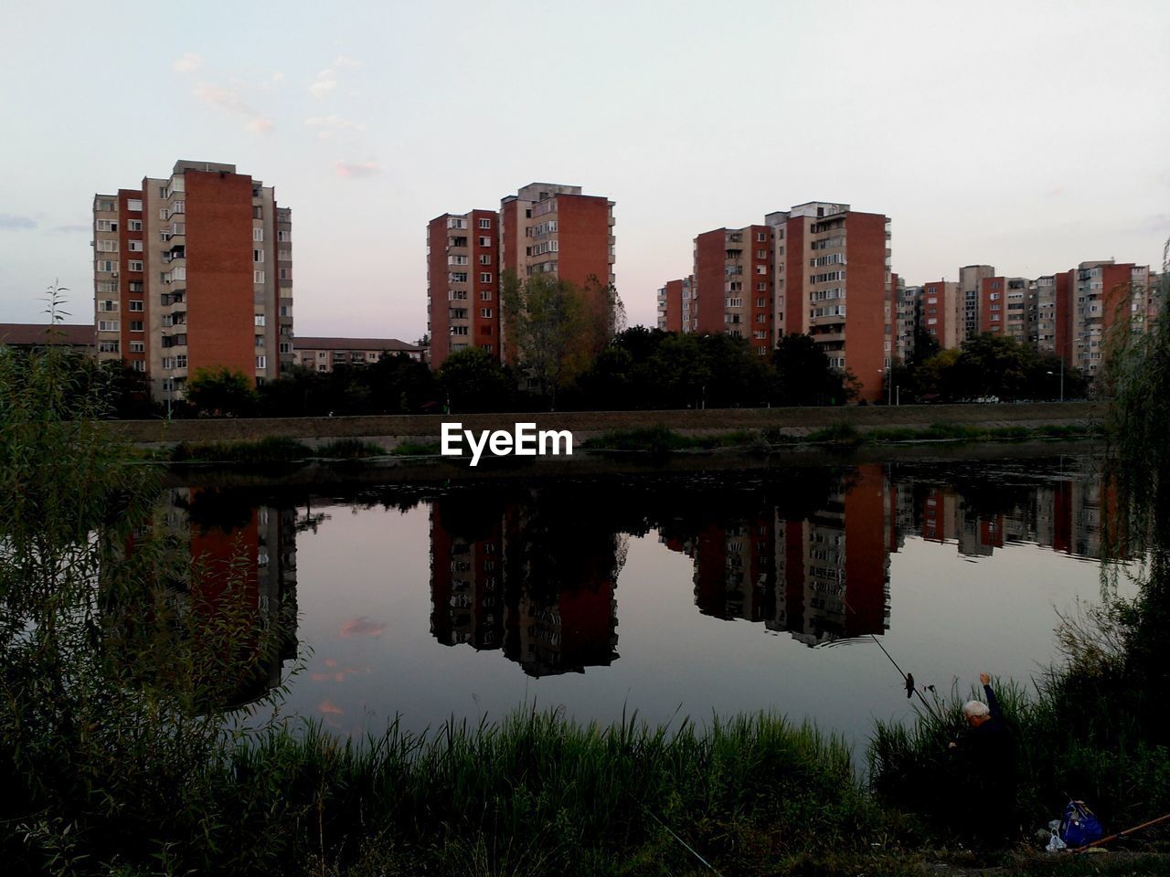 REFLECTION OF BUILDINGS ON CALM LAKE